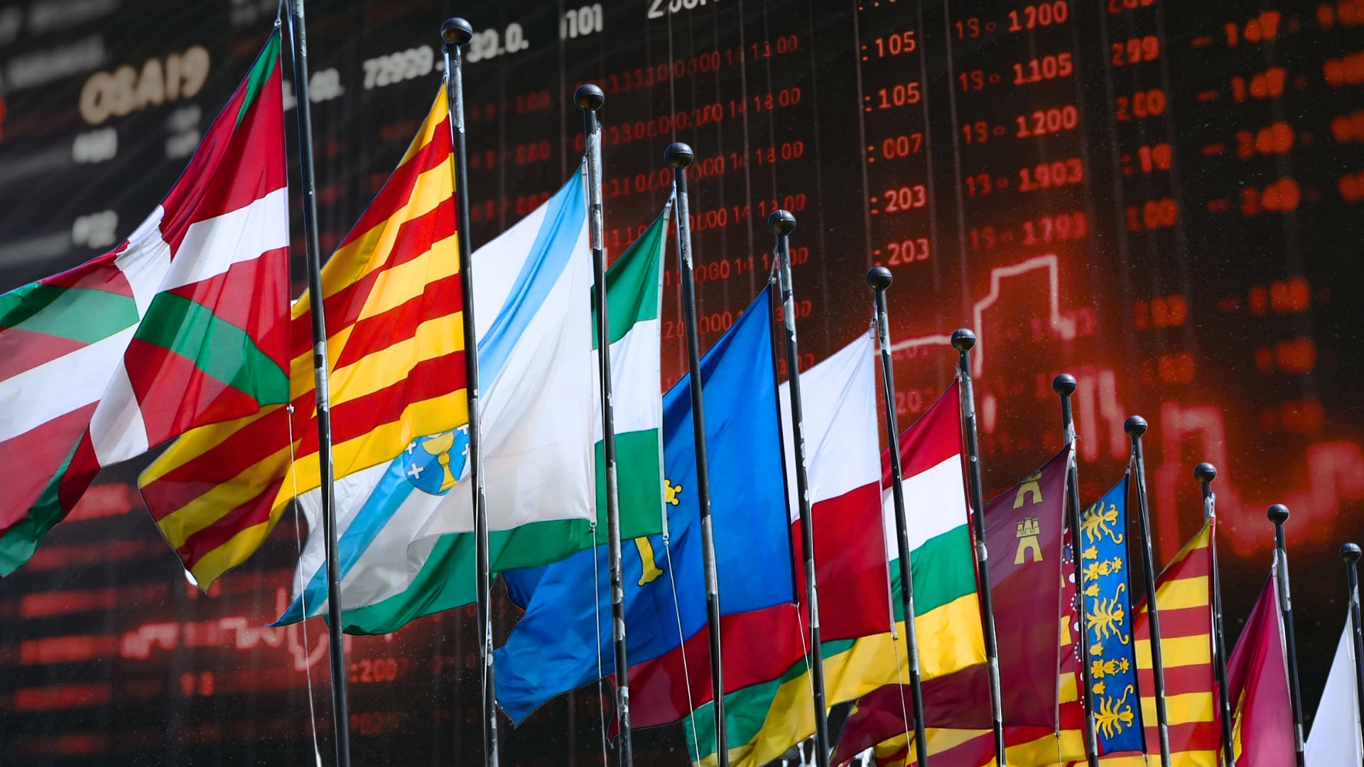 Composición fotográfica de una pantalla con inversiones y banderas de las distintas comunidades autónomas de España (Infobae)