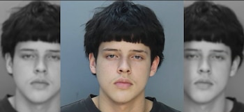 Fotografía policial de frente de un joven con cabello oscuro y camiseta negra sobre un fondo gris