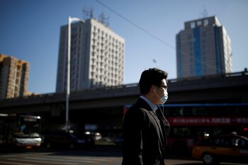 Un hombre con barbijo camina