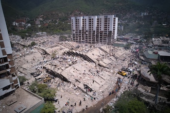 Residentes y rescatistas buscan entre los escombros dos días después de un sismo que remeció La Guaira, Venezuela, el 26 de junio de 2026. (AP Foto/Juan Pablo Arraez)
