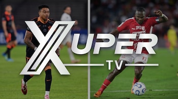 El logo de Xuper TV plateado sobre dos futbolistas en un campo de juego. Un jugador con camiseta oscura a la izquierda, otro con camiseta roja y un balón a la derecha.