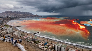 Vista aérea de ciudad costera peruana con personas apilando sacos de arena. El mar adyacente muestra zonas coloreadas en rojo y azul. Nubes oscuras se acercan.