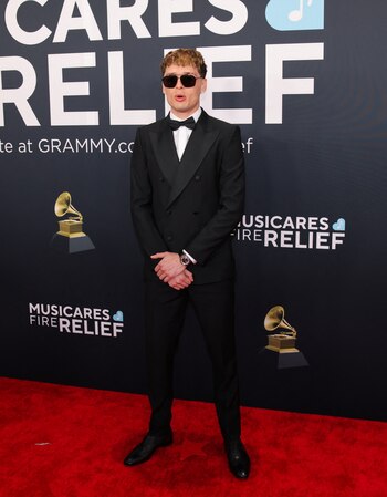 El cantante Peso Pluma eligió un clásico traje negro de corte ajustado con camisa blanca y moño. Es Dolce&Gabbana (REUTERS/Daniel Cole)