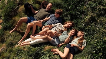 La tierna imagen familiar del príncipe Guillermo y Kate Middleton junto a sus tres hijos y su perro: descalzos, sonrientes y tumbados en la hierba