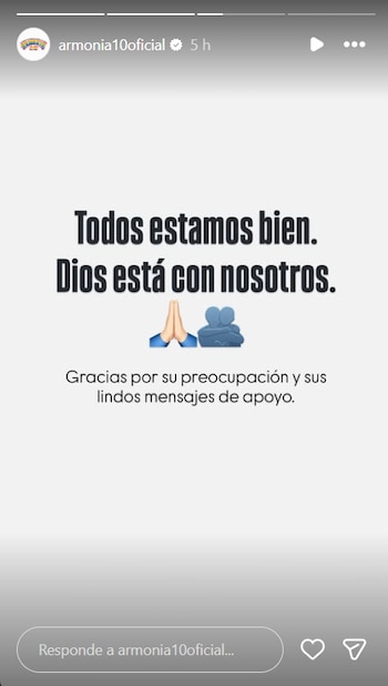 Captura de pantalla de historia de Instagram con fondo gris claro, texto "Todos estamos bien. Dios está con nosotros.", emojis de manos rezando y abrazo
