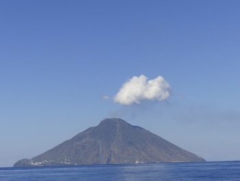En la isla se alza el volcán con una nube justo encima del cráter, que hace que parezca que ha salido de él