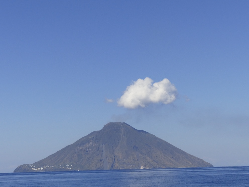 En la isla se alza el volcán con una nube justo encima del cráter, que hace que parezca que ha salido de él