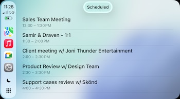 Pantalla de Apple CarPlay con un listado de reuniones programadas, iconos de aplicaciones como Mapas y Música, hora 11:28 y estado de batería