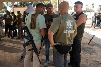 Miembros de Hermanos y Hermanas en Armas, un grupo de reservistas y veteranos israelíes que se oponen a las políticas del gobierno de extrema derecha de Israel, se reúnen en un punto de reunión en Beit Kama, en el sur de Israel, el 13 de octubre de 2023. Foto para The Washington Post por Baz Ratner.