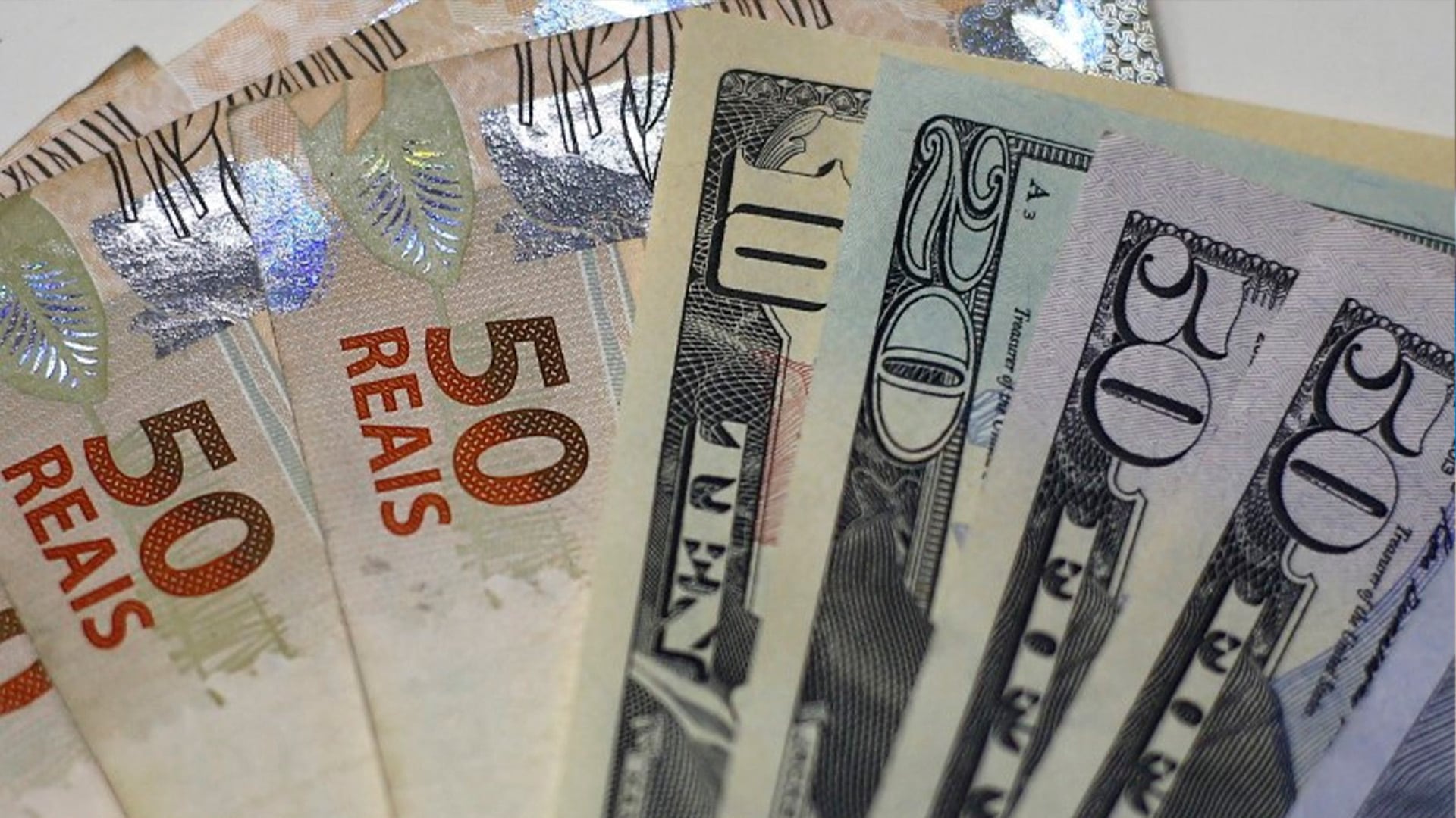 Billetes de reales brasileños y dólares estadounidenses aparecen en una oficina de cambio de divisas en Río de Janeiro (REUTERS/Ricardo Moraes/Archivo)