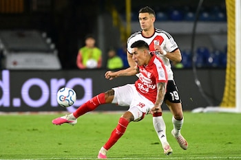 Santa Fe's Argentine defender #18 Emanuel Olivera and River Plate's Colombian forward #19 Rafael Santos Borre fight for the ball during the first leg of the Copa Sudamericana round of 16 football match between Colombia's Independiente Santa Fe and Argentina's River Plate at the Nemesio Camacho 'El Campin' stadium, in Bogota, on August 19, 2026. (Photo by Luis ACOSTA / AFP)