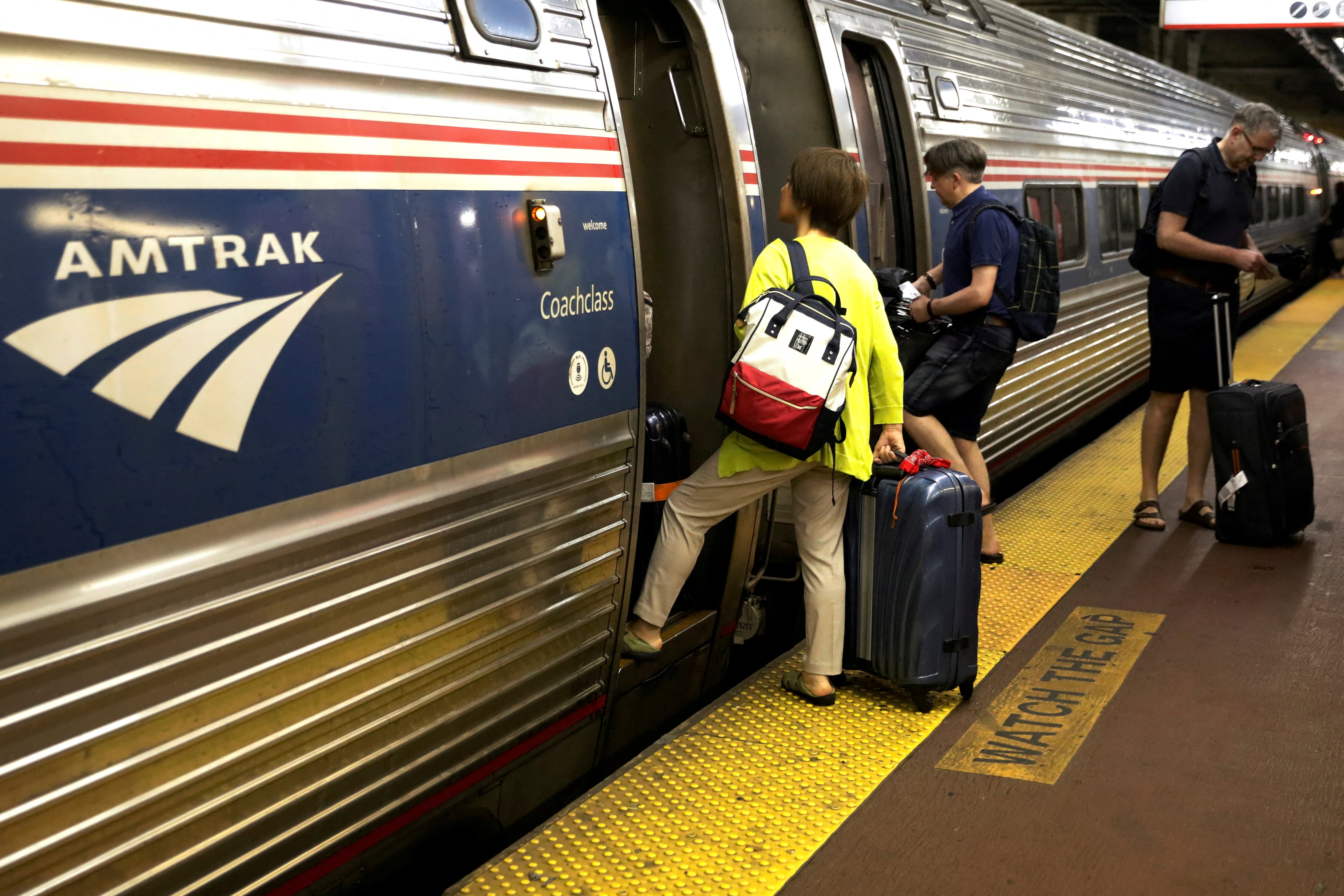 FILE PHOTO: Passengers board an Amtrak train inside New York
