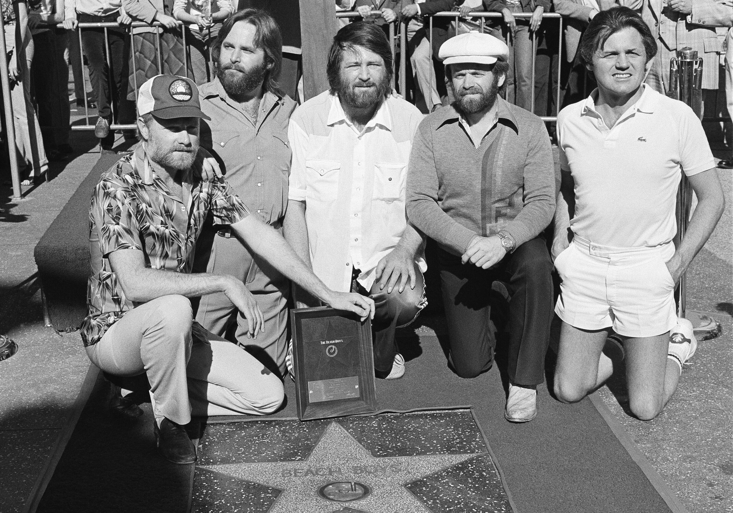 Los miembros de The Beach Boys, de izquierda a derecha, Mike Love, Carl Wilson, Brian Wilson, Al Jardine y Bruce Johnston, posan con su estrella en el Paseo de la Fama de Hollywood, durante una ceremonia en Los Ángeles el 30 de diciembre de 1980 (Foto: archivo AP/Lennox McLendon)