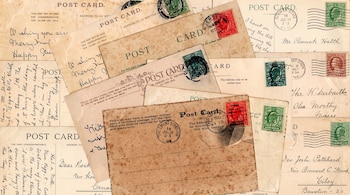 Tarjetas postales y cartas de papel envejecido con texto escrito a mano, sellos postales verdes y rojos, y marcas de matasellos.