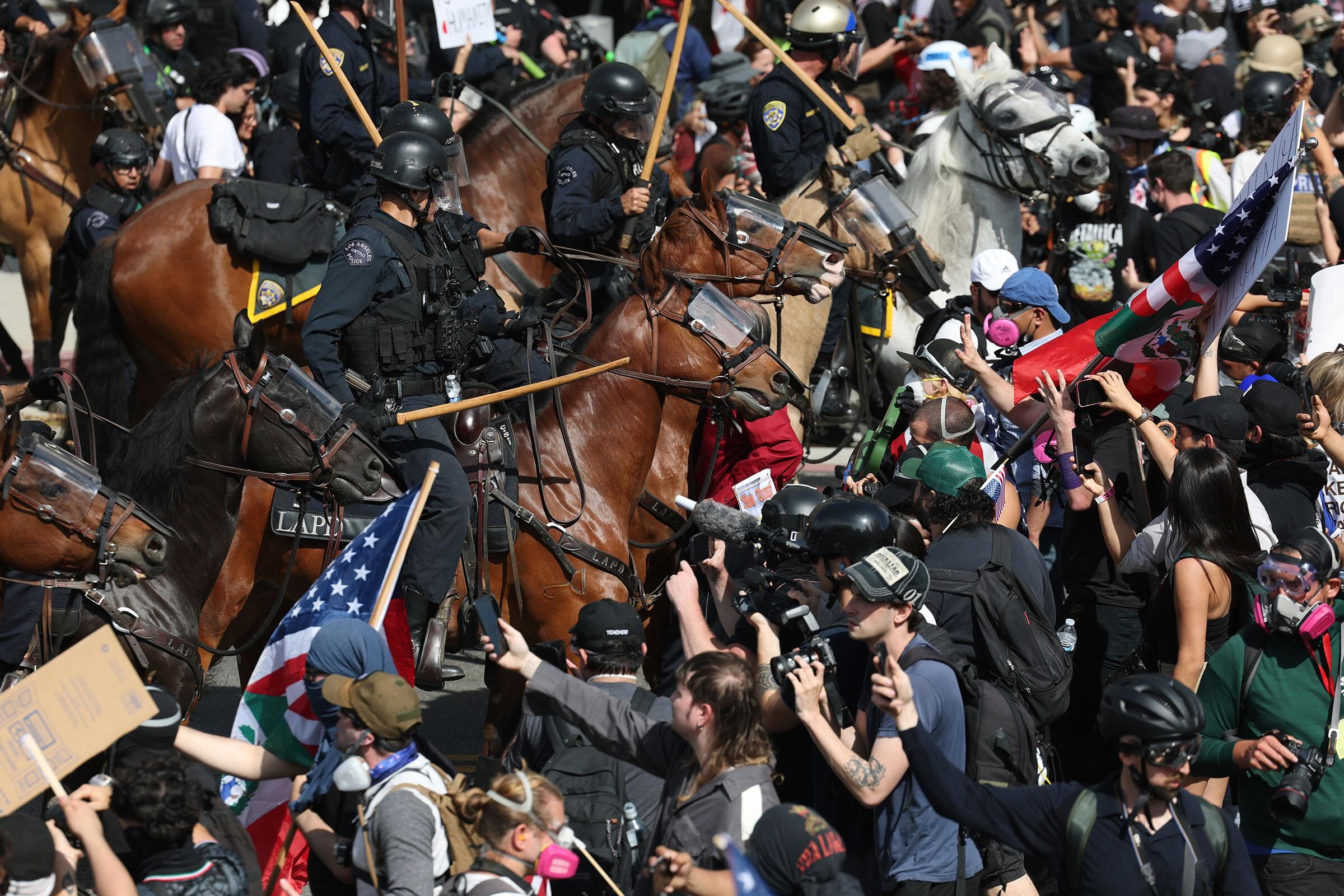 Manifestantes se enfrentaron a las fuerzas del orden a caballo durante una protesta en Los Ángeles, el 14 de junio (Ethan Swope—AP)