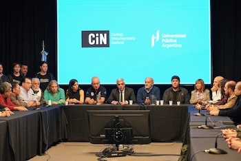 Panel de personas en una conferencia de prensa. Varios individuos sentados a una mesa larga. Detrás, una pantalla azul con los logos CiN y Universidad Pública Argentina