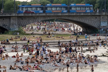 Bañistas en el río Isar en Múnich, Alemania, el 28 de junio de 2026. El país encadenó récords históricos de hasta 41,7°C que provocaron incendios y fallas en trenes. (P. Kneffel/dpa vía AP)