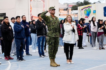 Un soldado y votantes escuchan
