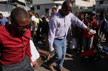 Trabajadores del ayuntamiento llevan el cuerpo de una persona que, junto con otras, fue asesinada a tiros en Puerto Príncipe (REUTERS/Ralph Tedy Erol)
