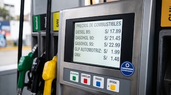 Pantalla digital de un surtidor de combustible con precios de diésel, gasohol y gas, junto a botones de colores y mangueras.