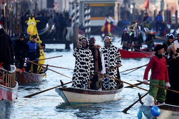 Juerguistas reman durante el desfile de máscaras en el Gran Canal