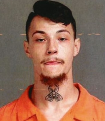 Fotografía policial de James Shirah, un hombre joven con cabello oscuro, bigote y perilla, vestido con un uniforme naranja y un tatuaje de polilla en el cuello