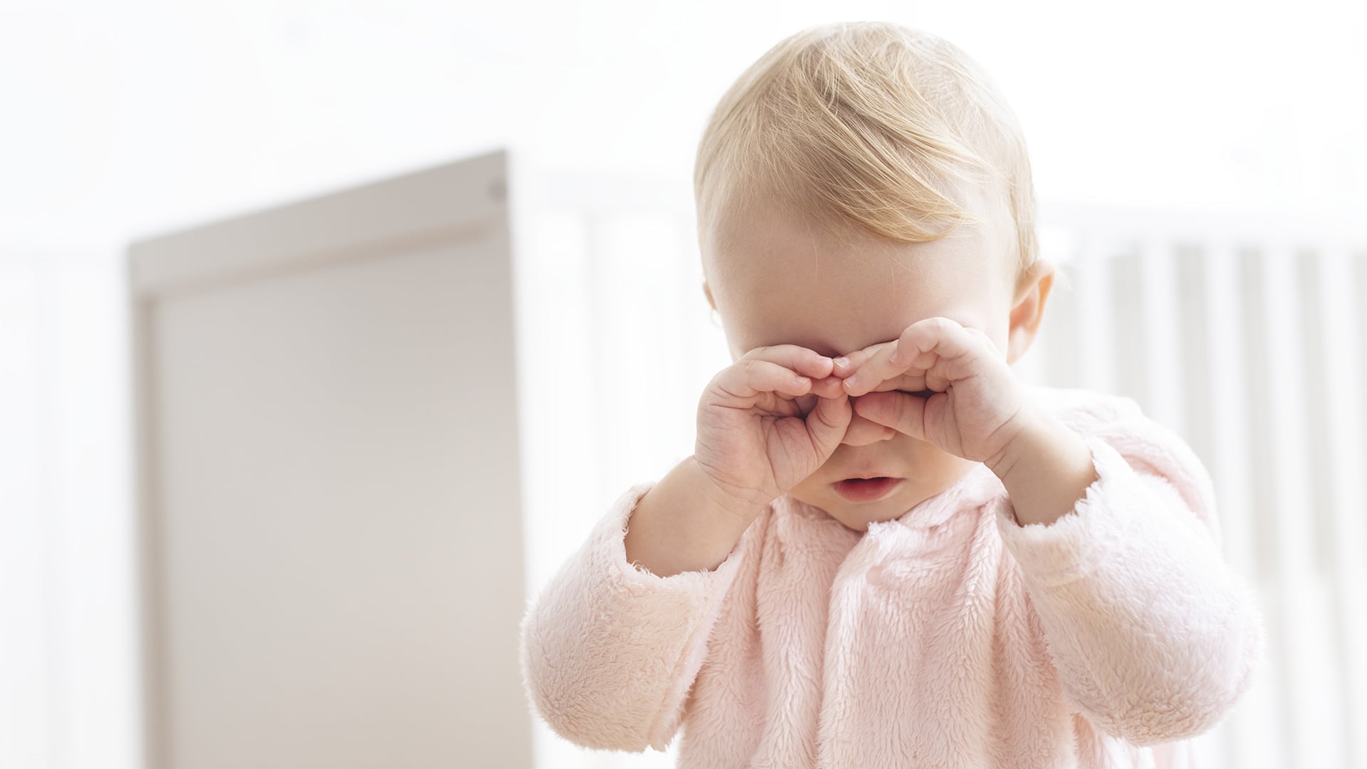 Baby girl crying and rubbing her eyes