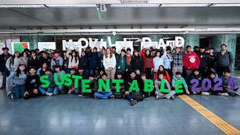 Un grupo de jóvenes posa en un vestíbulo sosteniendo letras de colores que forman las palabras Movilidad Sustentable 2024