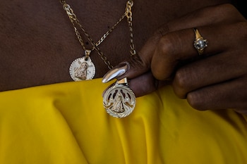 Yaneisy Frometa muestra su collar con la imagen de la Virgen de la Caridad del Cobre en el santuario de la Virgen en El Cobre, Cuba, el domingo 11 de febrero de 2024. (AP Foto/Ramón Espinosa)