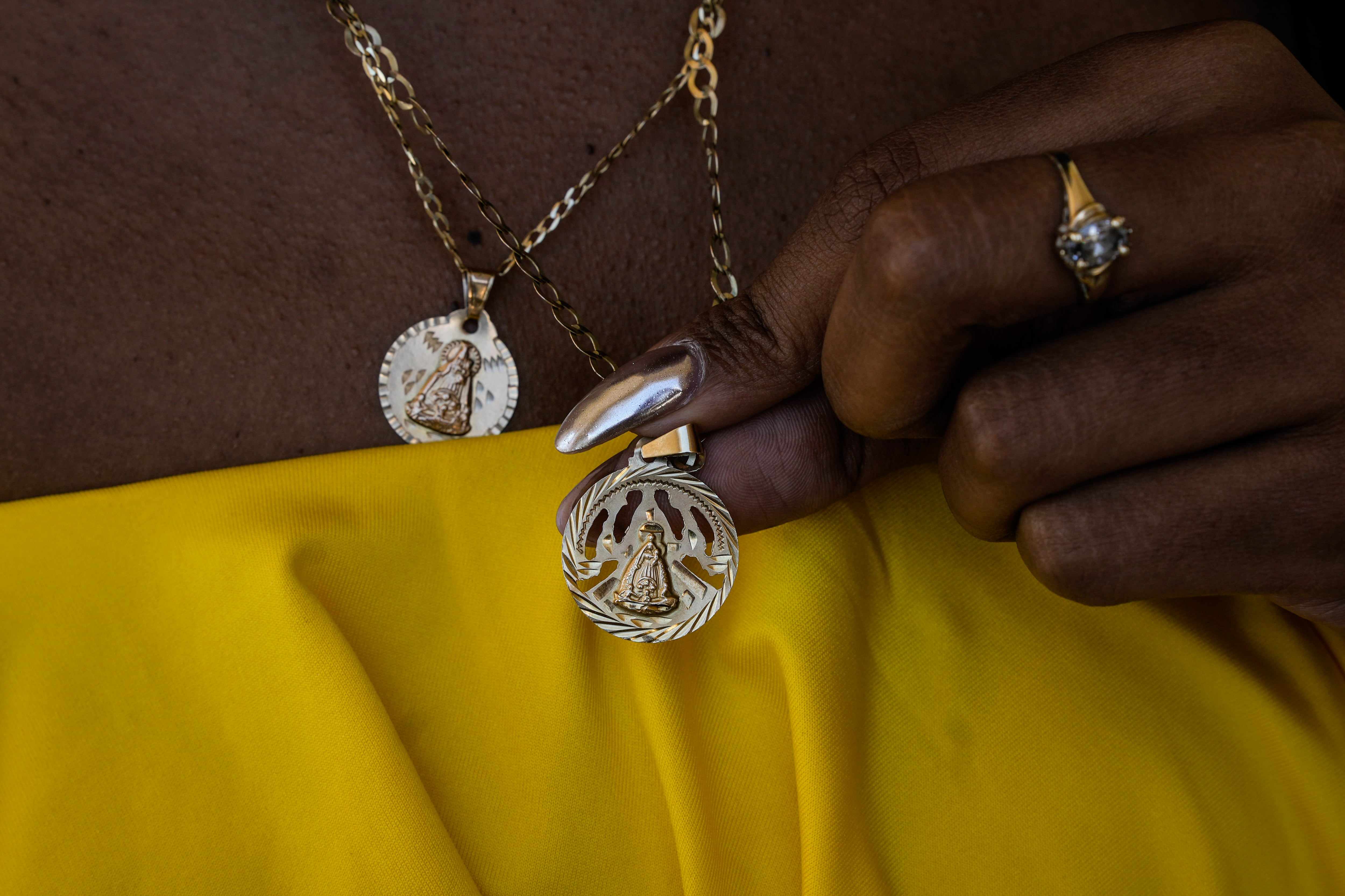 Yaneisy Frometa muestra su collar con la imagen de la Virgen de la Caridad del Cobre en el santuario de la Virgen en El Cobre, Cuba, el domingo 11 de febrero de 2024. (AP Foto/Ramón Espinosa)
