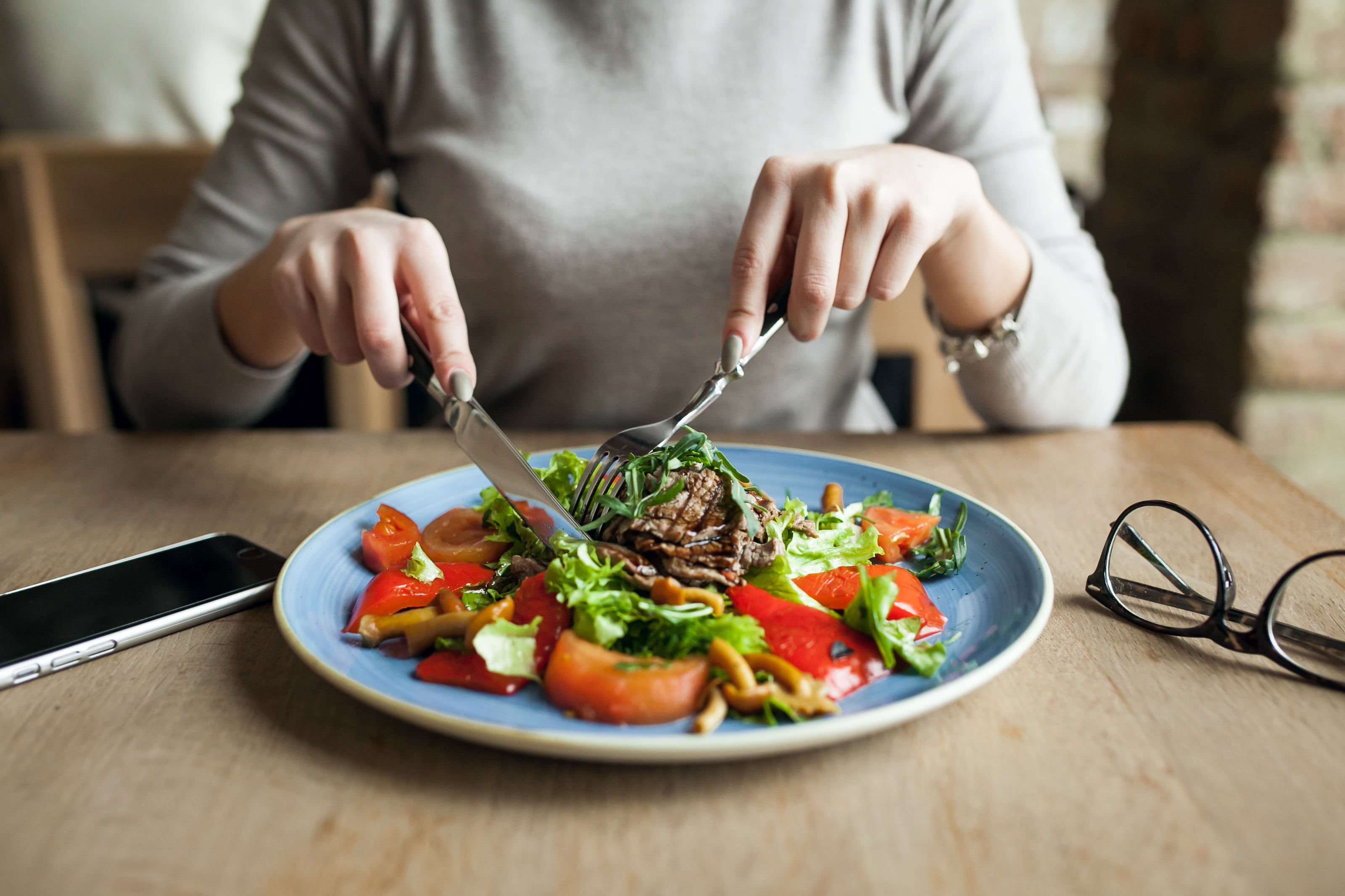 Una mujer comiendo un plato variado y equilibrado (Magnific)