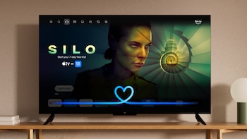 Una televisión de pantalla plana encendida sobre un mueble de madera, con una interfaz de streaming, aplicaciones y la promoción de la serie Silo