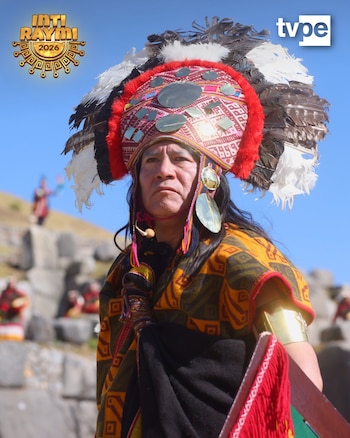 Hombre vestido como el Inca con tocado de plumas, túnica, brazalete dorado y un escudo. Fondo de cielo azul y ruinas de piedra. Logo Inti Raymi 2026 y tvpe
