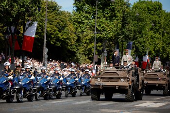 Macron, y el jefe del Estado Mayor de la Defensa, Thierry Burkhard, de pie en el coche de mando durante el desfile (REUTERS/Sarah Meyssonnier)