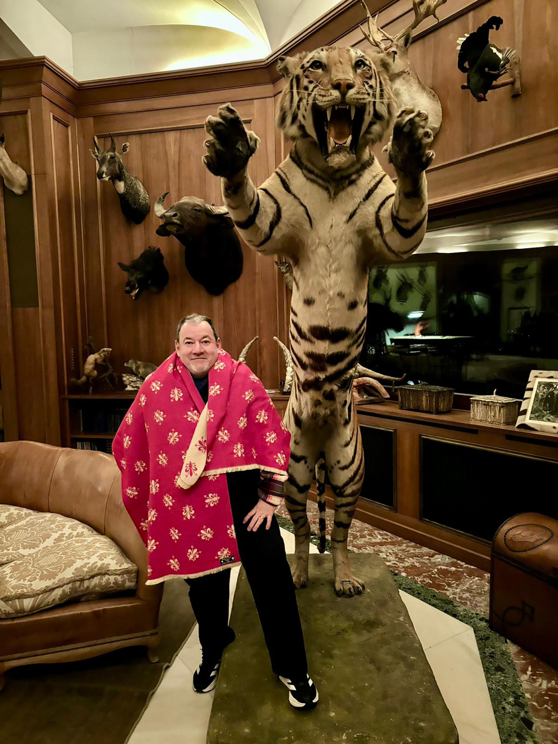 El chef argentino posa en el living del castillo junto a animales embalsamados