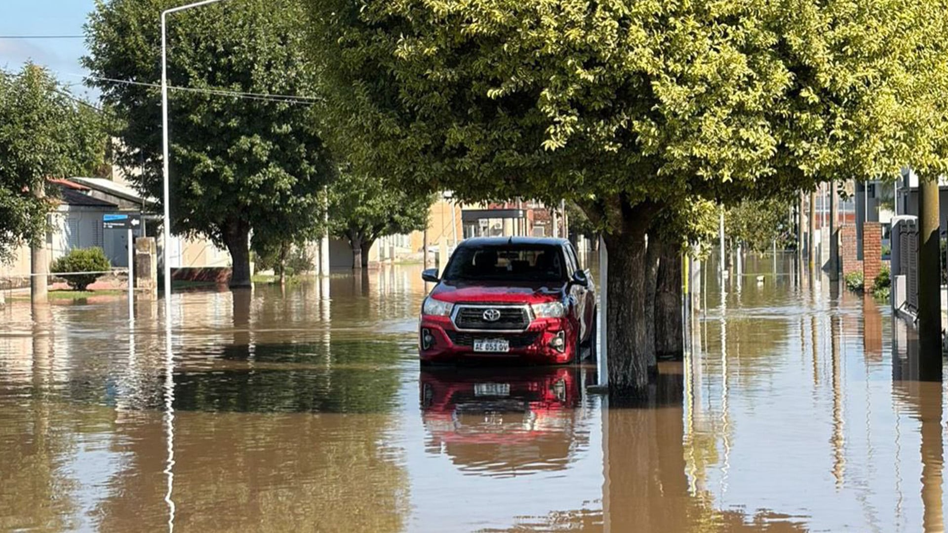 Una camioneta roja parcialmente sumergida en una calle inundada de Colonia Marina.
