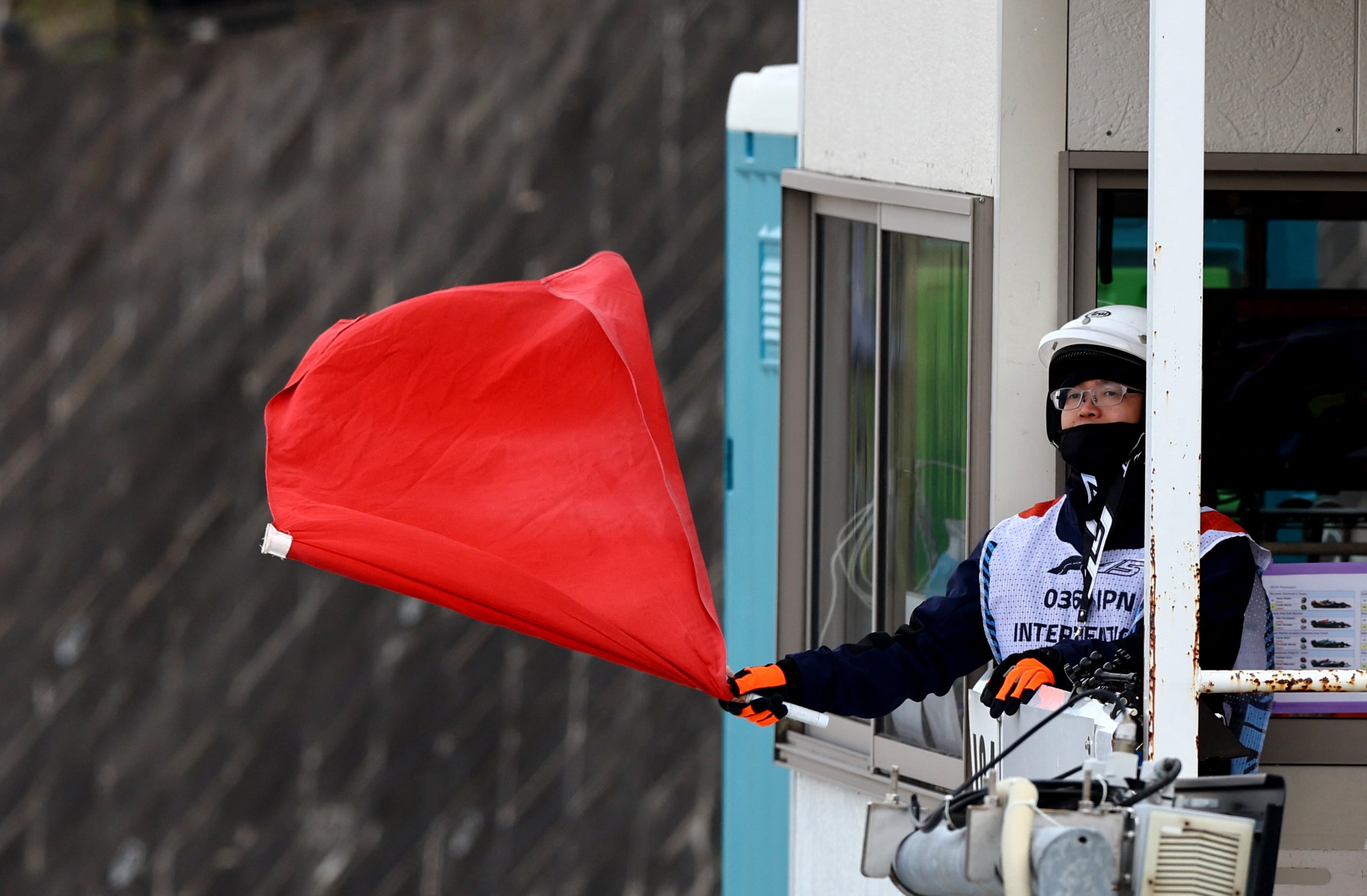 Los comisarios de pista se encargan de sacar a relucir las banderas a pista (REUTERS/Issei Kato)