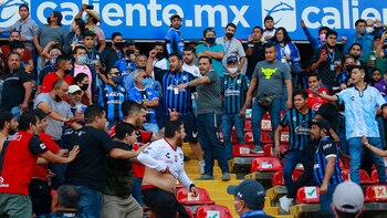 MEX7390. QUERÉTARO (MÉXICO), 05/03/2022.- Aficionados de Querétaro y Atlas se enfrentan al minuto 62, donde familias tuvieron que ser resguardadas en la cancha, durante un juego correspondiente a la jornada 9 del Torneo Clausura 2022 de la Liga MX del fútbol mexicano en el estadio Corregidora de la ciudad de Querétaro (México). EFE/Enrique Contla