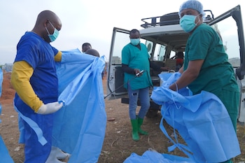 Trabajadores sanitarios se desinfectan tras enterrar a víctimas de ébola en Bunia, provincia de Ituri, República Democrática del Congo, el 18 de agosto del 2026. (AP foto/Dieudonne Dirole)