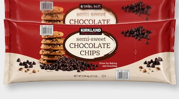 Dos bolsas de plástico rojas y crema con etiquetas de Kirkland Signature, chispas de chocolate semidulce y galletas de chocolate.