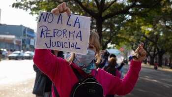 Una mujer sostiene un cartel