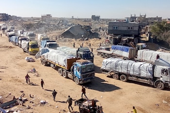 Palestinians run towards aid trucks