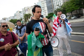 Supporters of Brazilian President Bolsonaro rally in favor of Bolsonaro's position that no one will be forced to use protective masks and get an eventual coronavirus vaccine, on Copacabana beach, in Rio de Janeiro, Brazil, Sunday, Nov. 1, 2020. Brazil has confirmed more than 159,000 deaths from the virus, the second highest in the world, behind only the U.S.(AP Photo/Bruna Prado)