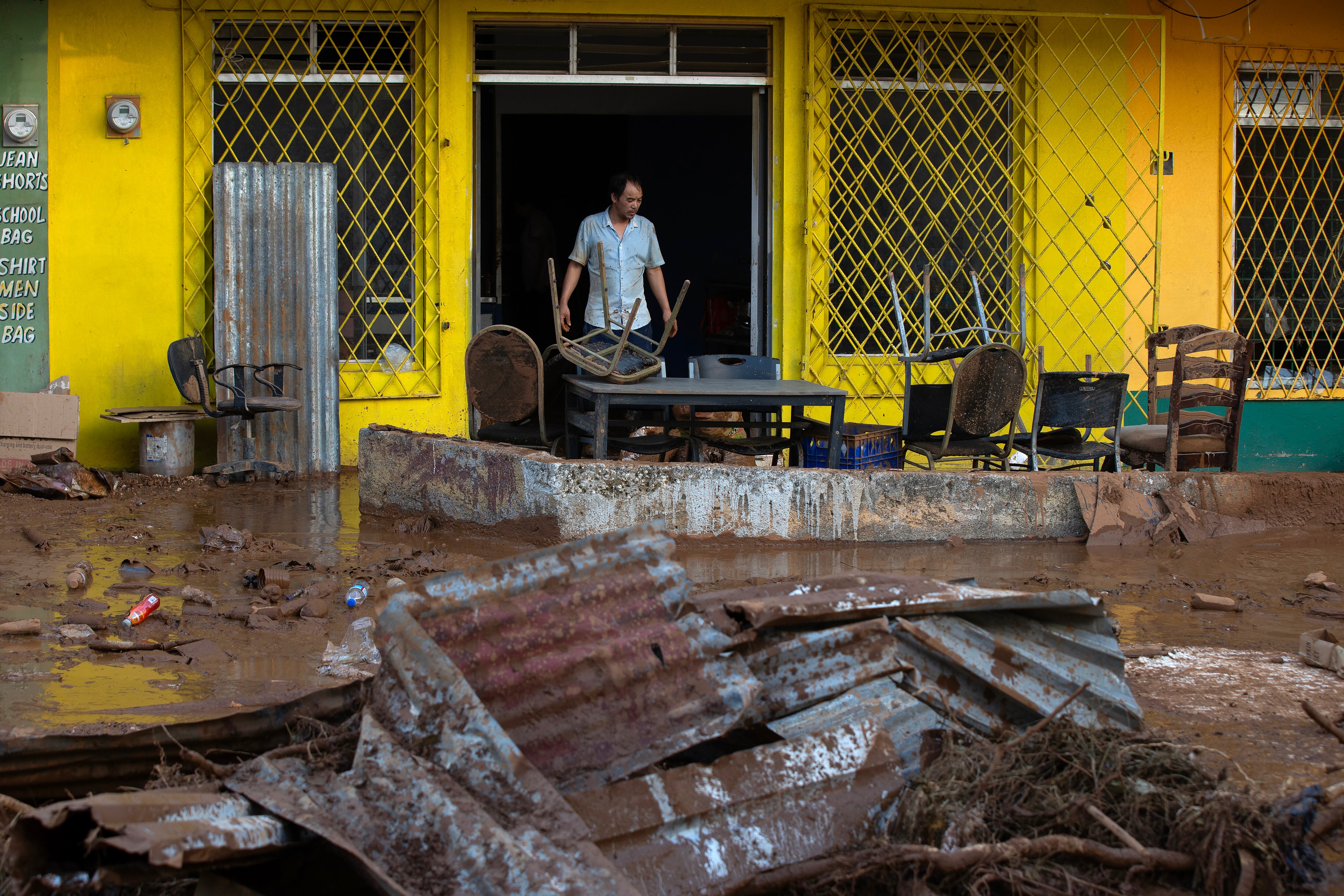 Una persona limpia pertenencias afectadas por el paso del huracán Melissa este jueves, en Santa Cruz (Jamaica). EFE/ Orlando Barría