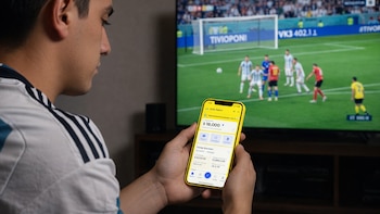 Equilibrio financiero en la era digital: un aficionado al fútbol gestiona su dinero desde el móvil - VisualesIA ScribNews