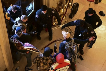 Demonstrators breach a door of