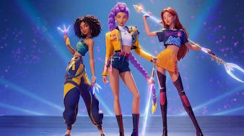 Imagen de tres mujeres animadas de estilo latino con atuendos modernos y coloridos. Posan con armas luminosas sobre un fondo azul con luces brillantes.