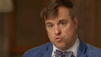 Primer plano de Jonathan Martin, un hombre de tez clara con cabello castaño corto y corbata de moño colorida, mirando directamente