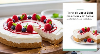 Una tarta de yogur blanca con base de galleta, decorada con frambuesas, arándanos y menta, con una porción retirada sobre una tabla de madera.