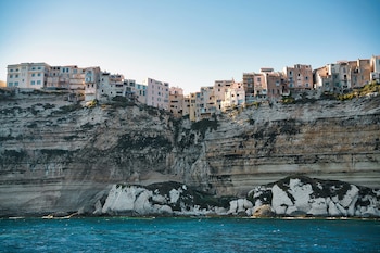 Edificios construidos en la parte superior de un alto acantilado rocoso junto a la superficie del mar